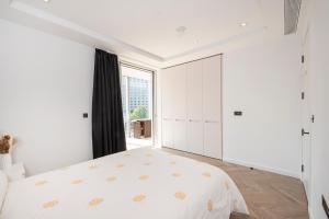a bedroom with white cabinets and a large window at Battersea Mall apartment in London