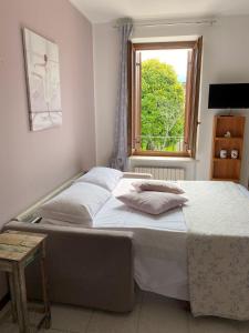 een groot bed in een slaapkamer met een raam bij Dolce Dormire appartamento fiore in Negrar