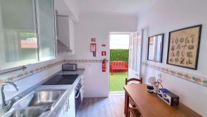 a white kitchen with a sink and a window at Afonso Galo Guest Apartments III in Almada