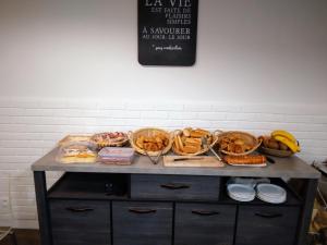 a table with many baskets of food on it at Hôtel Le Vauban in Carentan