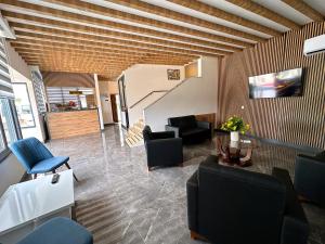 a living room with a couch and chairs and a staircase at KAYA GARDEN OTEL in Side