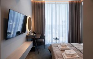 ウージュホロドにあるWHITE HILLS HOTEL spa&sportのベッドと大きな窓が備わるホテルルームです。
