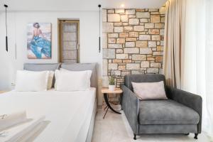 ein Schlafzimmer mit einem Sofa und einem Stuhl in der Unterkunft Brothers Apartments in Skala Potamias