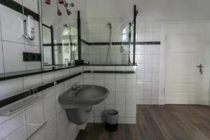 a bathroom with a sink and a toilet and a mirror at Hotel Berliner Hof in Remscheid