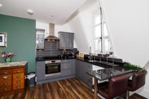 a kitchen with a counter and a table in it at Pearl Chambers in Leeds City Centre in Leeds