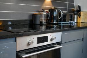 a kitchen with a stove with a counter top at Pearl Chambers in Leeds City Centre in Leeds