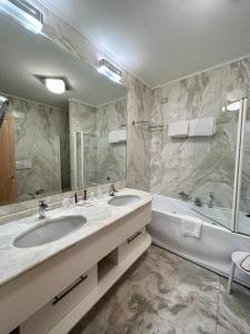 a bathroom with two sinks and a tub and a mirror at Foscari Palace in Venice