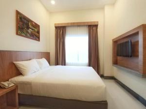 um quarto de hotel com uma cama e uma televisão em Bintan Lumba Lumba Inn Hotel em Tanjung Pinang