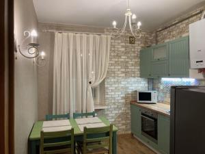 a kitchen with green cabinets and a table with chairs at Власне Паркомісце! Апартаменти у новобудові, Городоцька street in Lviv