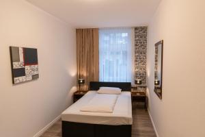 een kleine kamer met een bed en een raam bij Hotel Berliner Hof in Remscheid