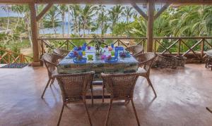 a table on a porch with chairs and a table with at Villa Ibiscus in Las Galeras