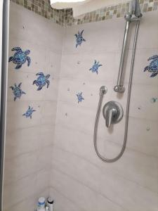 y baño con ducha y ladillas azules en la pared. en Viky House, en Catania