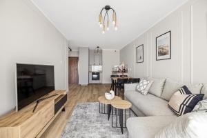 a living room with a couch and a table at Marina Primore - Hampton Apartments in Gdańsk