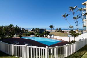 a swimming pool with a white fence and a building at Colonial Sands 403 in Margate