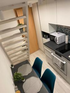 una pequeña cocina con mesa y sillas azules en Downtown Mini Apartment, en Budapest