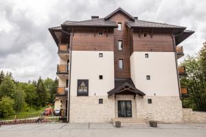 un grande edificio con facciata marrone e bianca di ZLATIBOR HIGHLAND a Zlatibor