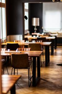 Hotel Berliner Hof في رمشيد: غرفة طعام مع طاولات وكراسي خشبية