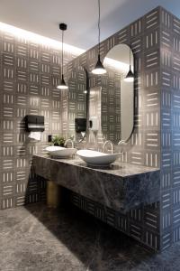 a bathroom with two sinks and a large mirror at Mexication Penthouse: Urban Retreat Col. American in Guadalajara