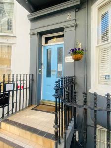 una puerta azul en una casa con una valla en Blue Sky Guest House, en Brighton & Hove