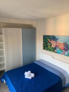una camera da letto con un letto blu con due asciugamani di LE DIMORE DI VIA VENEZIA a Civitanova Marche