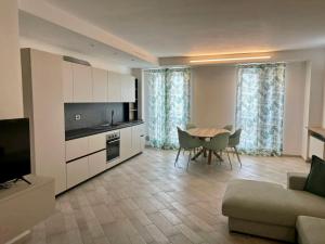 a kitchen and living room with a table and a couch at Appartamento Borgomarina in Cervia
