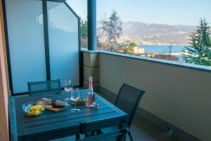 een tafel met een fles wijn en glazen op een balkon bij 180° on the lake in Pella