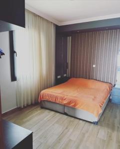 a bedroom with a bed with an orange sheet at PİNK POİNT APART in Didim