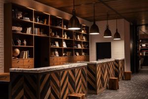 a bar in a room with shelves and pendant lights at Four Points by Sheraton Nagoya, Chubu International Airport in Tokoname
