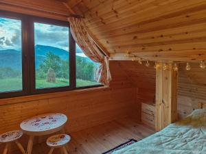 um quarto com uma cama e dois bancos num chalé de madeira em Almost Heaven - cabană cu vedere în Apuseni em Cimpeni