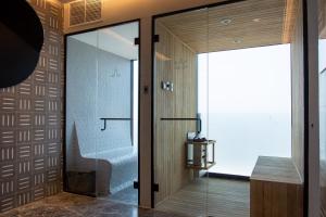 a glass door leading into a bathroom with a chair at Mexication Penthouse: Urban Retreat Col. American in Guadalajara +15 photos