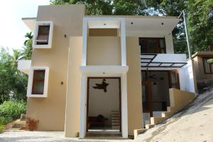 uma pequena casa ao lado de uma praia em Kandy Lotus House em Kandy