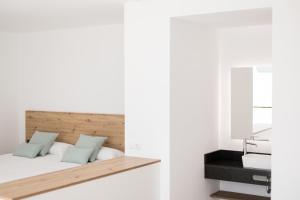 Schlafzimmer mit einem Bett und einem Spiegel in der Unterkunft Bossa Bay Suites with Private Pool - MC Apartments Ibiza in Ibiza-Stadt