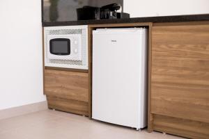 un frigorifero bianco in una cucina accanto al forno a microonde di Bossa Bay Suites with Private Pool - MC Apartments Ibiza a Ibiza Città