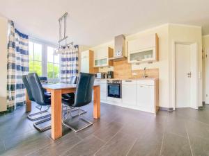 a kitchen with a table and chairs in a room at De Möhlenkieker 3 in Greetsiel