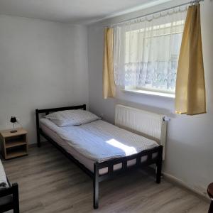 Habitación pequeña con cama y ventana en Noclegi, en Starogard Gdański