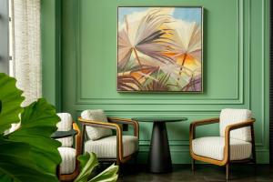 una habitación con 2 sillas, una mesa y una pintura en The Ritz-Carlton, Grand Cayman en George Town