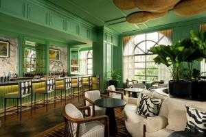 un restaurante con paredes verdes, sillas y mesas en The Ritz-Carlton, Grand Cayman, en George Town