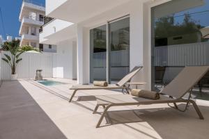 dwa salony i dwa krzesła na patio domu w obiekcie Bossa Bay Suites with Private Pool - MC Apartments Ibiza w mieście Ibiza