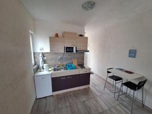 eine kleine Küche mit einem Waschbecken und einem Tisch in der Unterkunft BenJak Apartments in Hvar