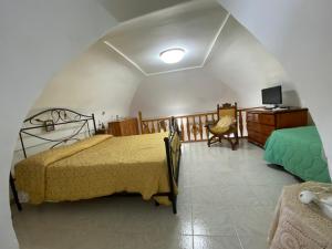 a bedroom with a bed and a desk and a television at La Casa dei Sogni in Procida