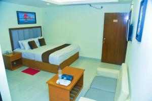 a hotel room with a bed and a table with a table at Hotel Crown City in Chittagong