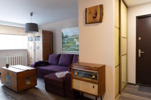 - un salon avec un canapé violet et une table dans l'établissement Holiday Apartment, à Roja