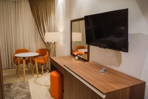 a hotel room with a flat screen tv on the wall at Diamond Land Hotel in Madinat Al Ashir min Ramadan