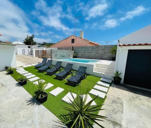 a row of lounge chairs and a swimming pool at Soares Village II in Amoreira