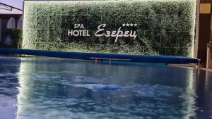 a pool of water in front of a hedge at Spa Hotel Ezeretz Blagoevgrad in Blagoevgrad