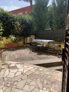 a patio with a table and chairs on a stone floor at Miini loft di pregio a Roma Nord- Ponte Milvio in Rome