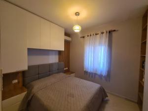 een slaapkamer met een bed en een raam bij Apartamento Famiglia vacanza in Mullini i Danit