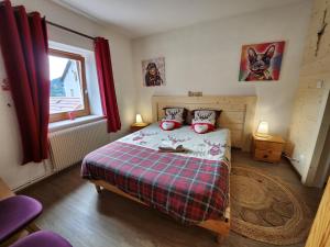 een slaapkamer met een bed met rode gordijnen en een raam bij Gite Myosotis 2 personnes avec SPA Jacuzzi , jardin, barbecue, dans la Résidence in Ventron