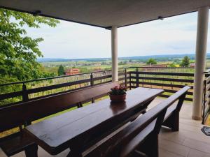 a wooden bench on a balcony with a view at Sweet Hideout Filovci in Filovci
