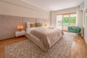 a bedroom with a large bed and a large window at Belo Horizonte Apart in Parede